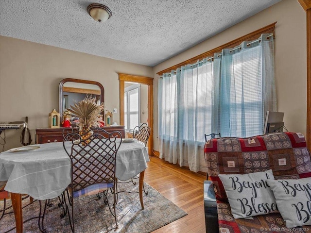 dining area with a textured ceiling and wood finished floors