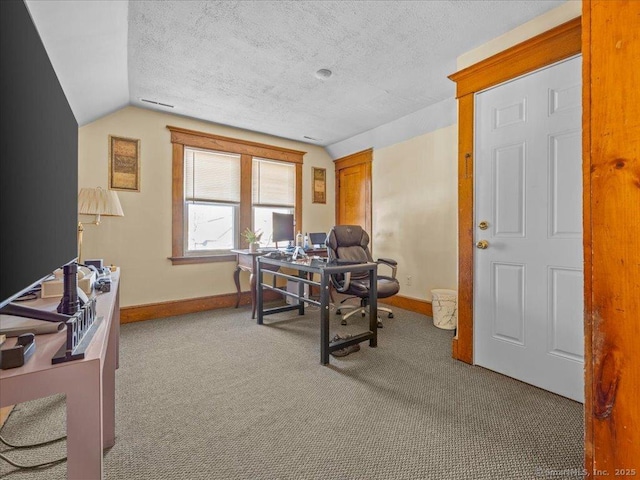 office space with baseboards, a textured ceiling, lofted ceiling, and carpet floors