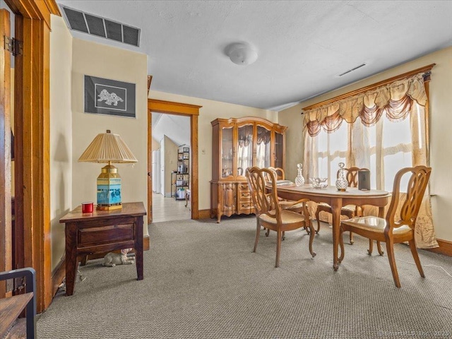 carpeted dining area with visible vents and baseboards