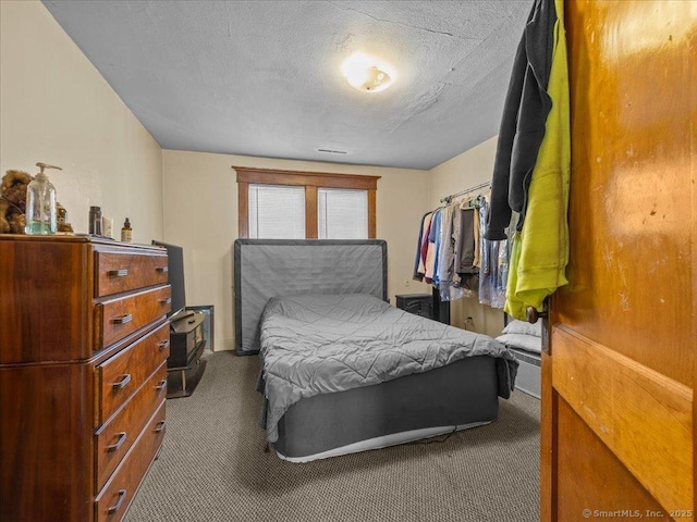 bedroom with a textured ceiling and carpet floors