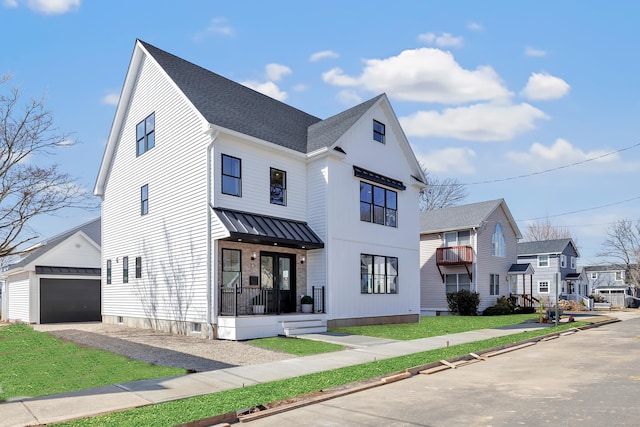 modern farmhouse featuring an outdoor structure, covered porch, a residential view, and a shingled roof