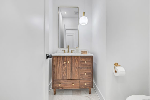 half bathroom with vanity, toilet, visible vents, and baseboards