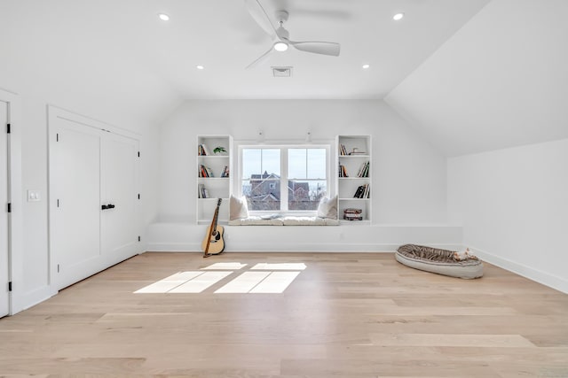 additional living space with lofted ceiling, wood finished floors, visible vents, and ceiling fan