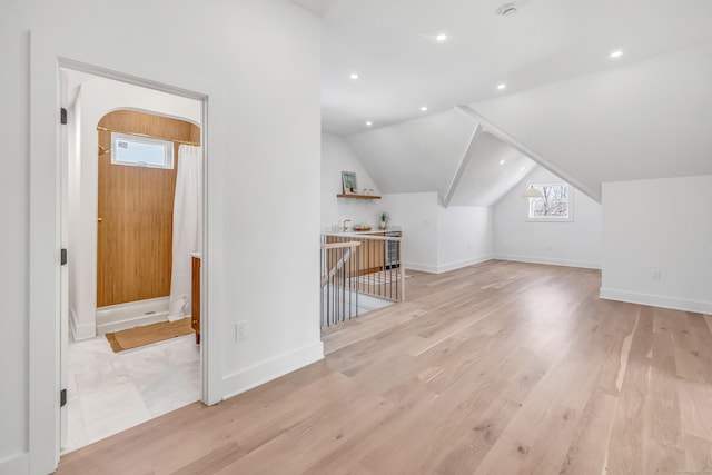 bonus room featuring baseboards, light wood-type flooring, and lofted ceiling