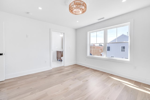 spare room with recessed lighting, visible vents, light wood-style flooring, and baseboards