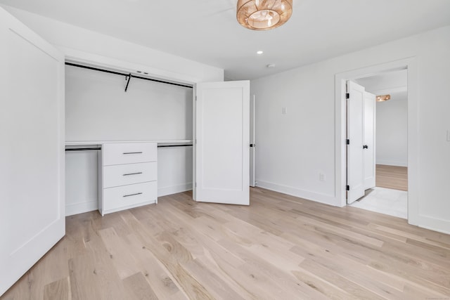 unfurnished bedroom featuring recessed lighting, a closet, baseboards, and light wood-style flooring