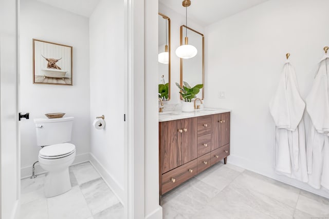 full bathroom featuring double vanity, toilet, baseboards, and a sink