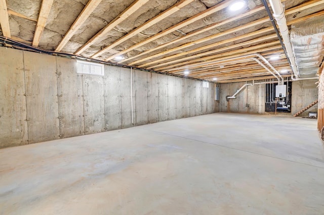 unfinished basement with electric panel and water heater