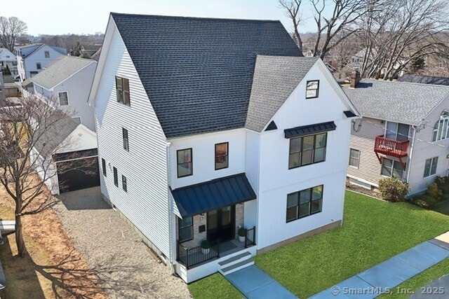 view of front of house with a front yard, a residential view, and roof with shingles