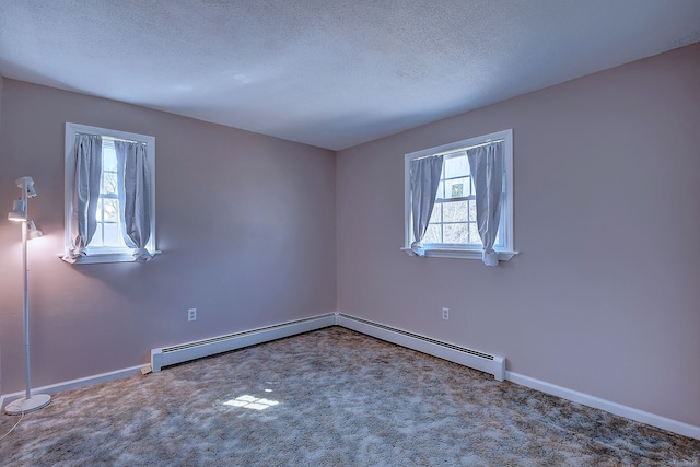 unfurnished room featuring a baseboard heating unit, carpet floors, a textured ceiling, and baseboards