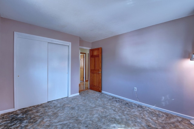 unfurnished bedroom with a closet, baseboards, and carpet