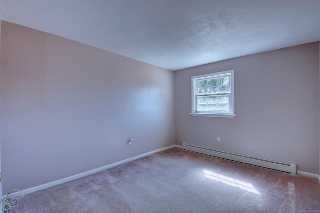 carpeted spare room featuring baseboard heating, a textured ceiling, and baseboards