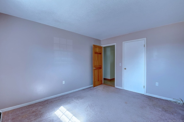 unfurnished bedroom featuring a textured ceiling, baseboards, and carpet floors