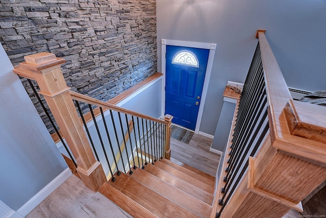 staircase featuring wood finished floors and baseboards