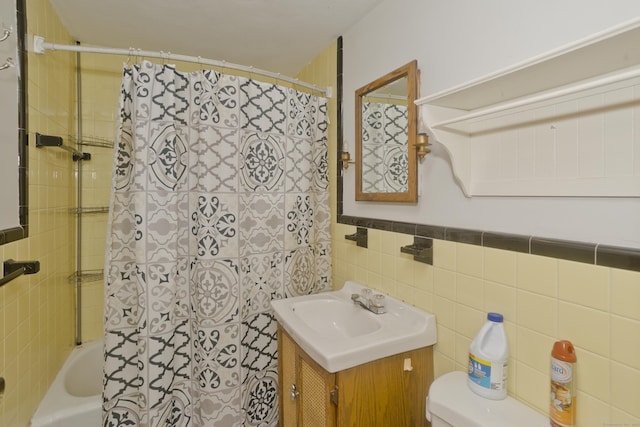 bathroom featuring vanity, tile walls, toilet, and shower / tub combo with curtain