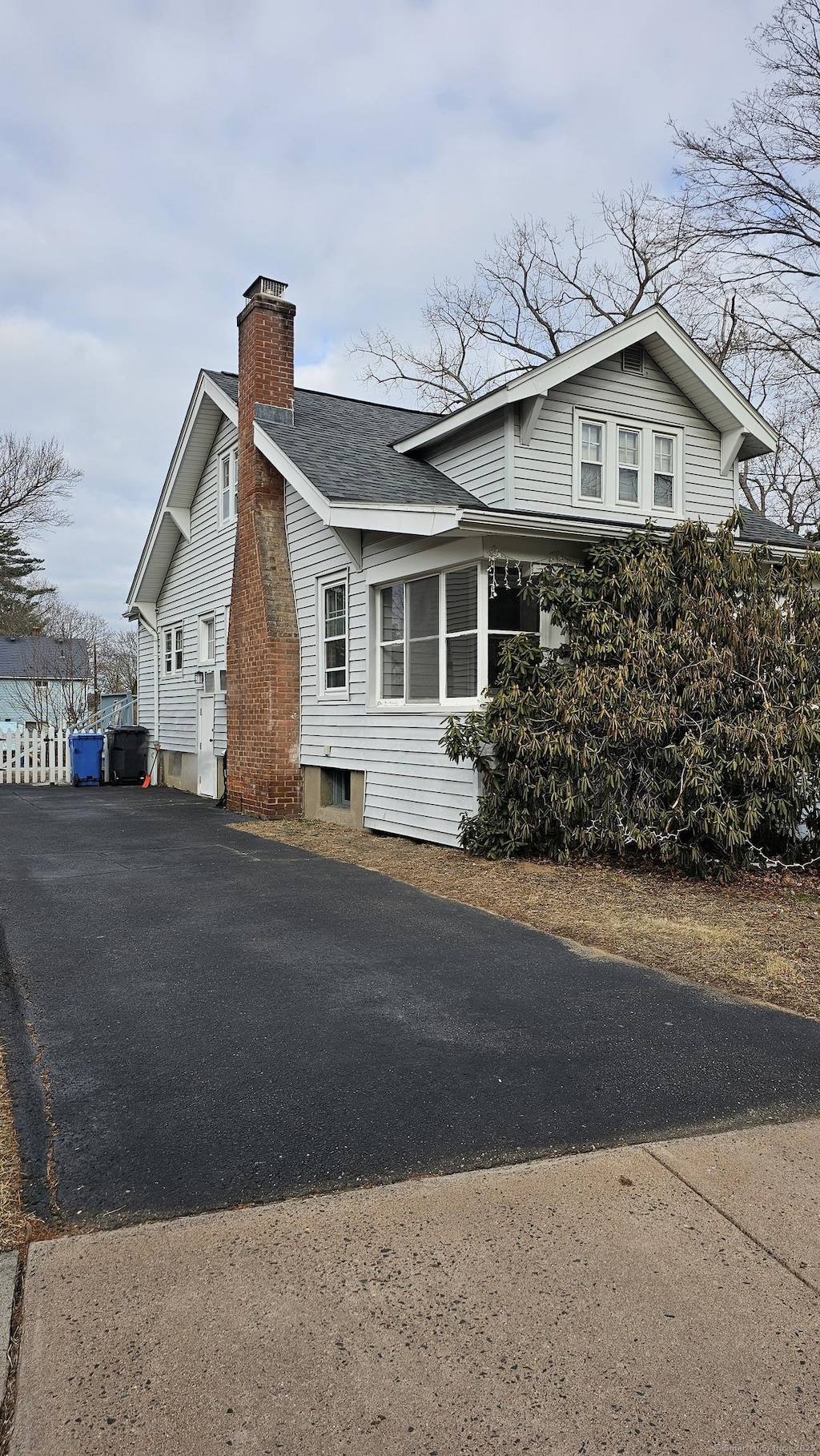 view of home's exterior with driveway and a chimney