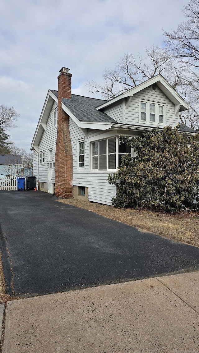 view of home's exterior with driveway and a chimney