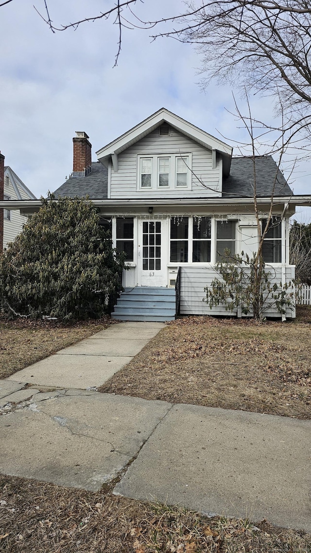 traditional home with a chimney and a shingled roof