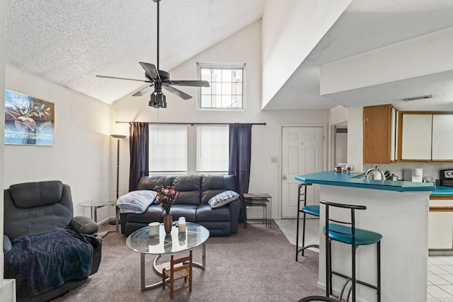 living area with light colored carpet, a textured ceiling, ceiling fan, and vaulted ceiling