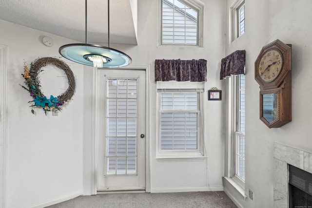 doorway to outside featuring a fireplace and carpet