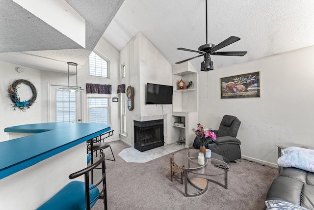 living area with a fireplace with flush hearth, a textured ceiling, carpet, and vaulted ceiling