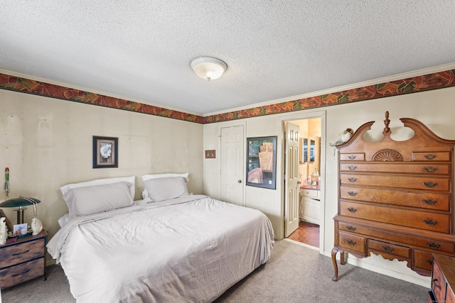 bedroom featuring connected bathroom, carpet floors, and a textured ceiling