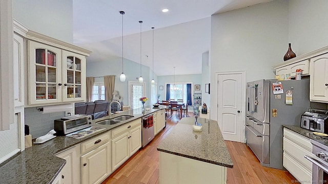 105 Mashentuck Rd, Killingly, CT 06239 - kitchen featuring appliances with stainless steel finishes, a sink, high vaulted ceiling, glass insert cabinets, and light wood-type flooring