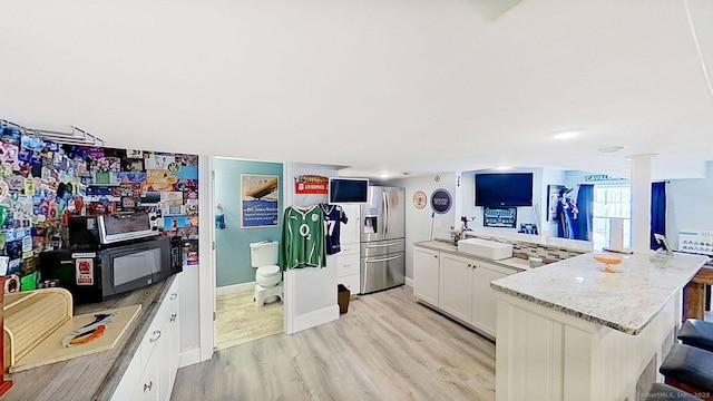 105 Mashentuck Rd, Killingly, CT 06239 - kitchen with stainless steel fridge with ice dispenser, a sink, light wood-style floors, white cabinets, and a kitchen breakfast bar