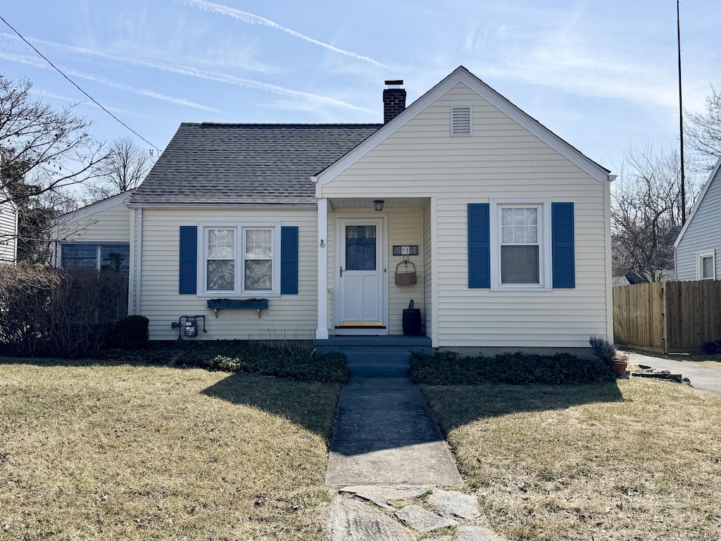 bungalow-style home featuring a front lawn, roof with shingles, a chimney, and fence