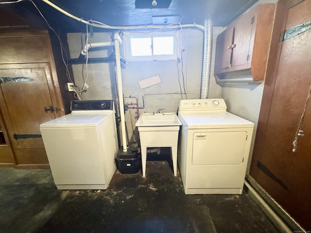 washroom with a sink, cabinet space, and separate washer and dryer