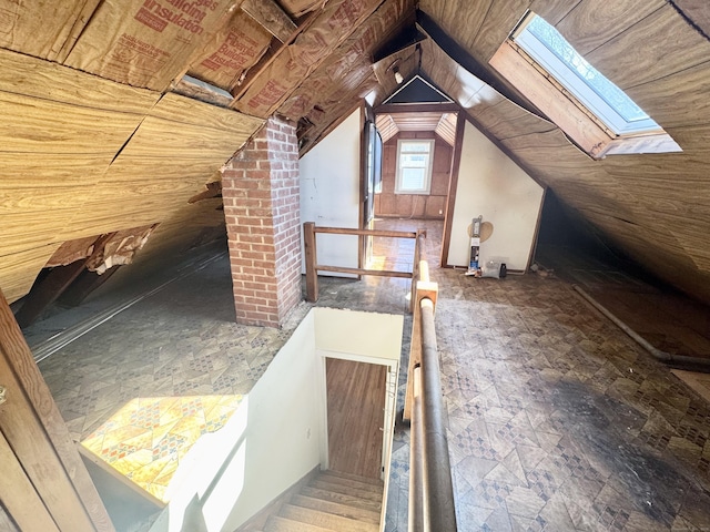 unfinished attic featuring an upstairs landing and a skylight