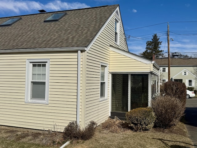 view of side of home featuring roof with shingles