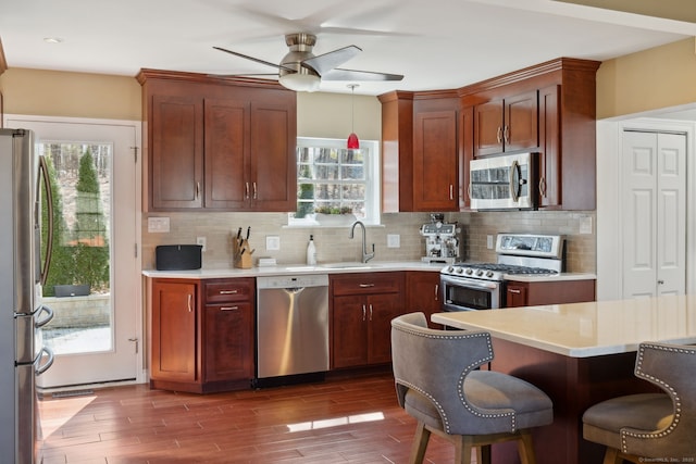 kitchen featuring a sink, appliances with stainless steel finishes, a ceiling fan, and light countertops