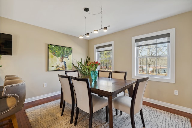 dining space with wood finished floors and baseboards