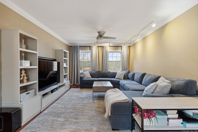 living area featuring rail lighting, ornamental molding, and a ceiling fan