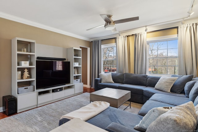 living area featuring a ceiling fan, crown molding, and a healthy amount of sunlight