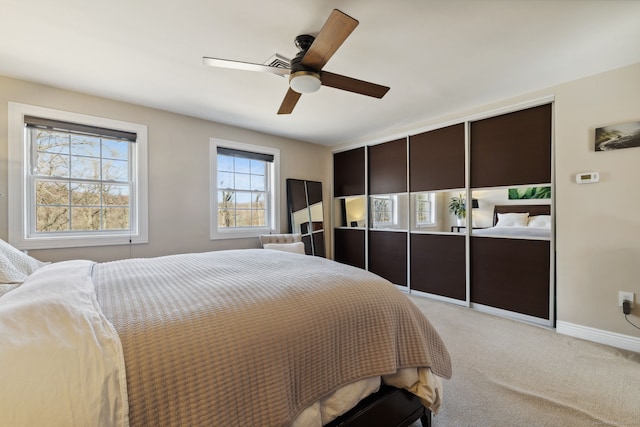 bedroom with light carpet, ceiling fan, and baseboards