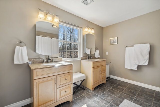 bathroom featuring a sink, visible vents, baseboards, and two vanities