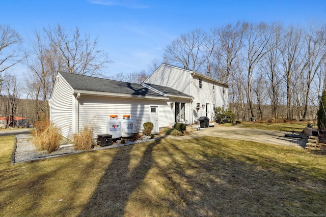 back of house featuring entry steps and a yard