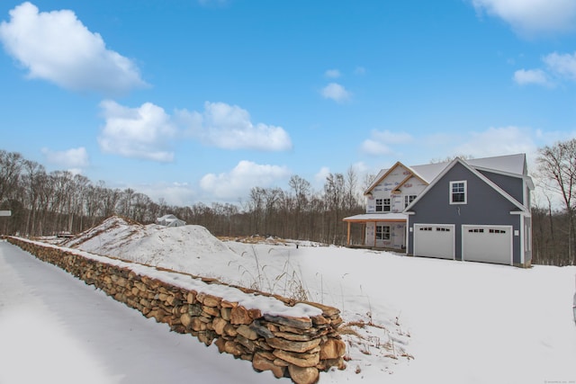 yard layered in snow featuring an attached garage