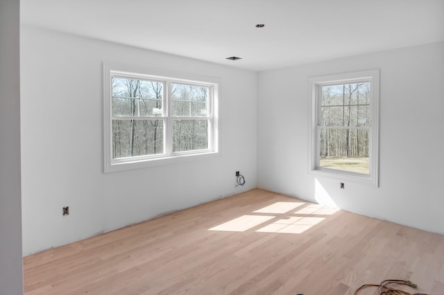 empty room with wood finished floors and a wealth of natural light