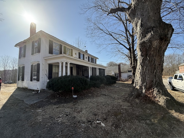 view of front of home with a porch and a chimney