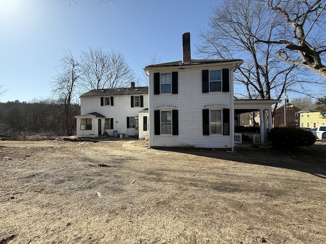 rear view of property featuring a chimney