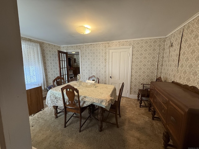 carpeted dining area featuring wallpapered walls and ornamental molding