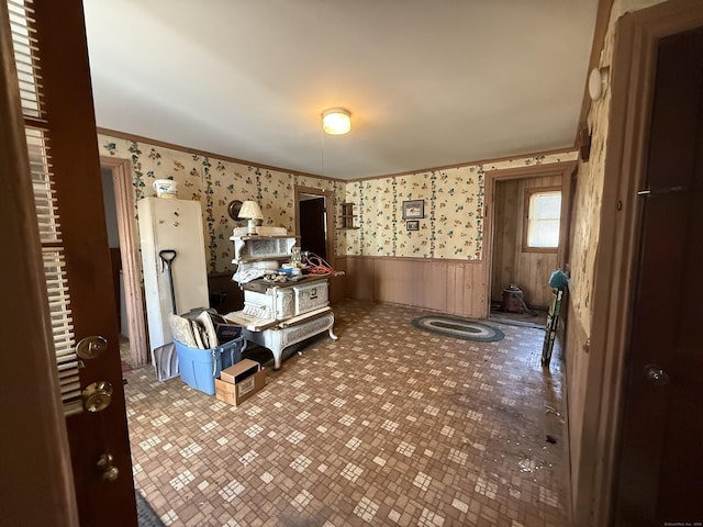 interior space with wainscoting, wallpapered walls, and crown molding