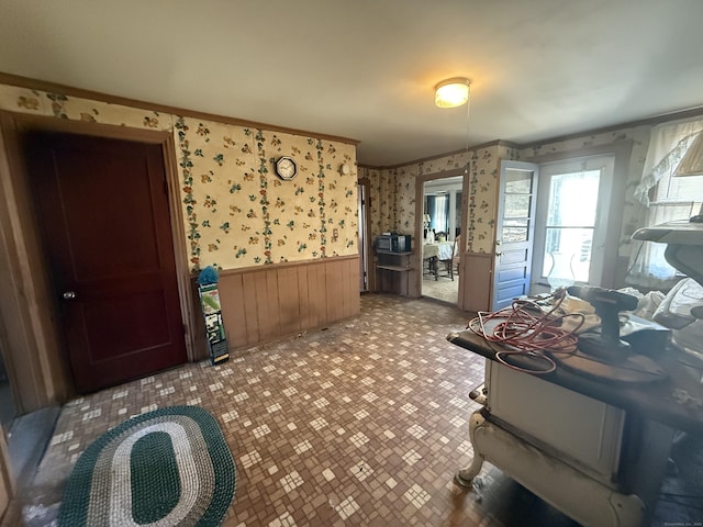 misc room featuring wallpapered walls, a wainscoted wall, and ornamental molding