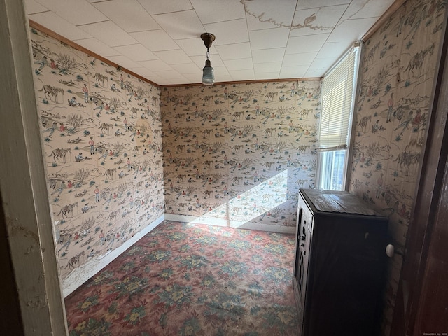 unfurnished dining area with wallpapered walls and baseboards