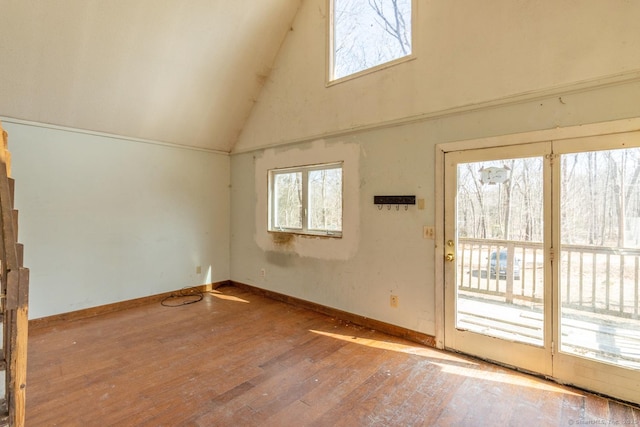 interior space with vaulted ceiling, baseboards, and wood-type flooring