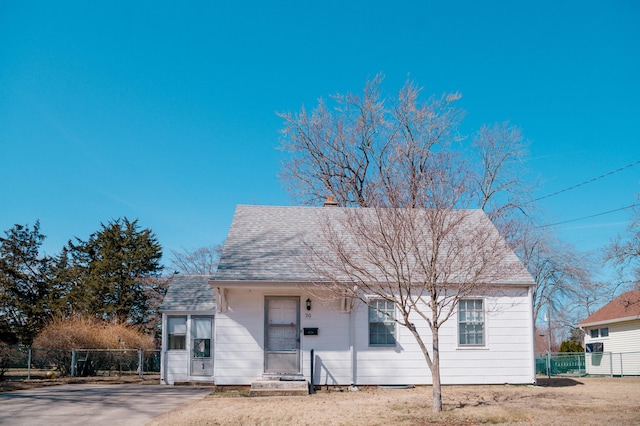 view of front of home with roof with shingles and fence