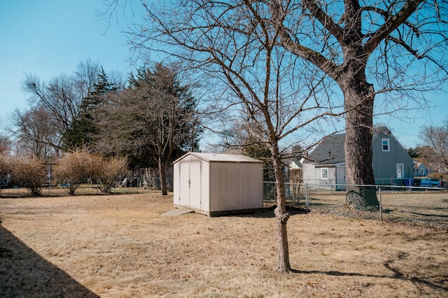 view of yard featuring a storage unit, an outbuilding, and a fenced backyard